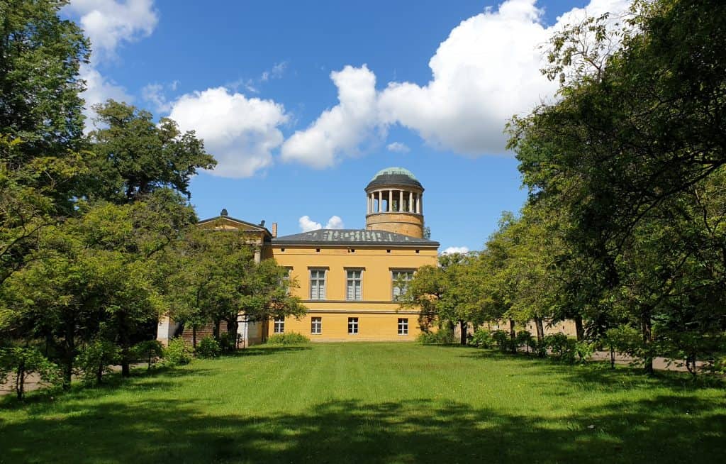 Seitenansicht von Schloss Lindstedt aus dem parkähnlichen Garten in Potsdam